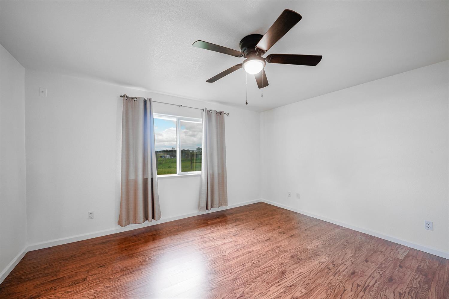 37491 Verde Avenue Madera, CA 93636 - Photo 43 of 66 a view of a big room with wooden floor and windows