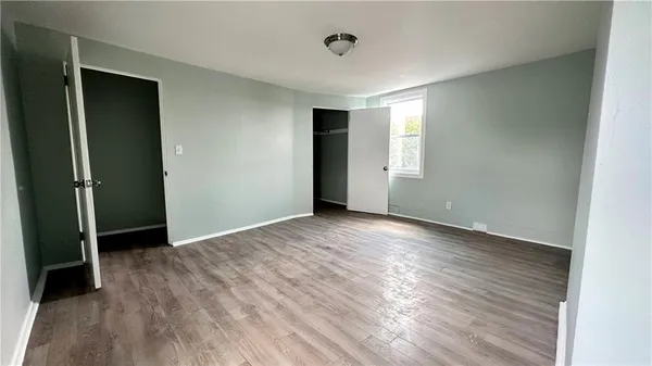 an empty room with wooden floor and closet