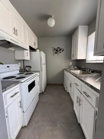 a kitchen with white cabinets and white appliances