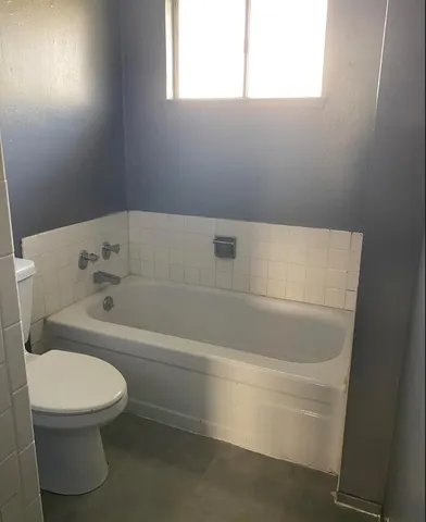 a white bath tub sitting next to a toilet