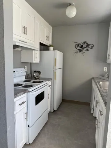 a kitchen with a stove cabinets and a refrigerator