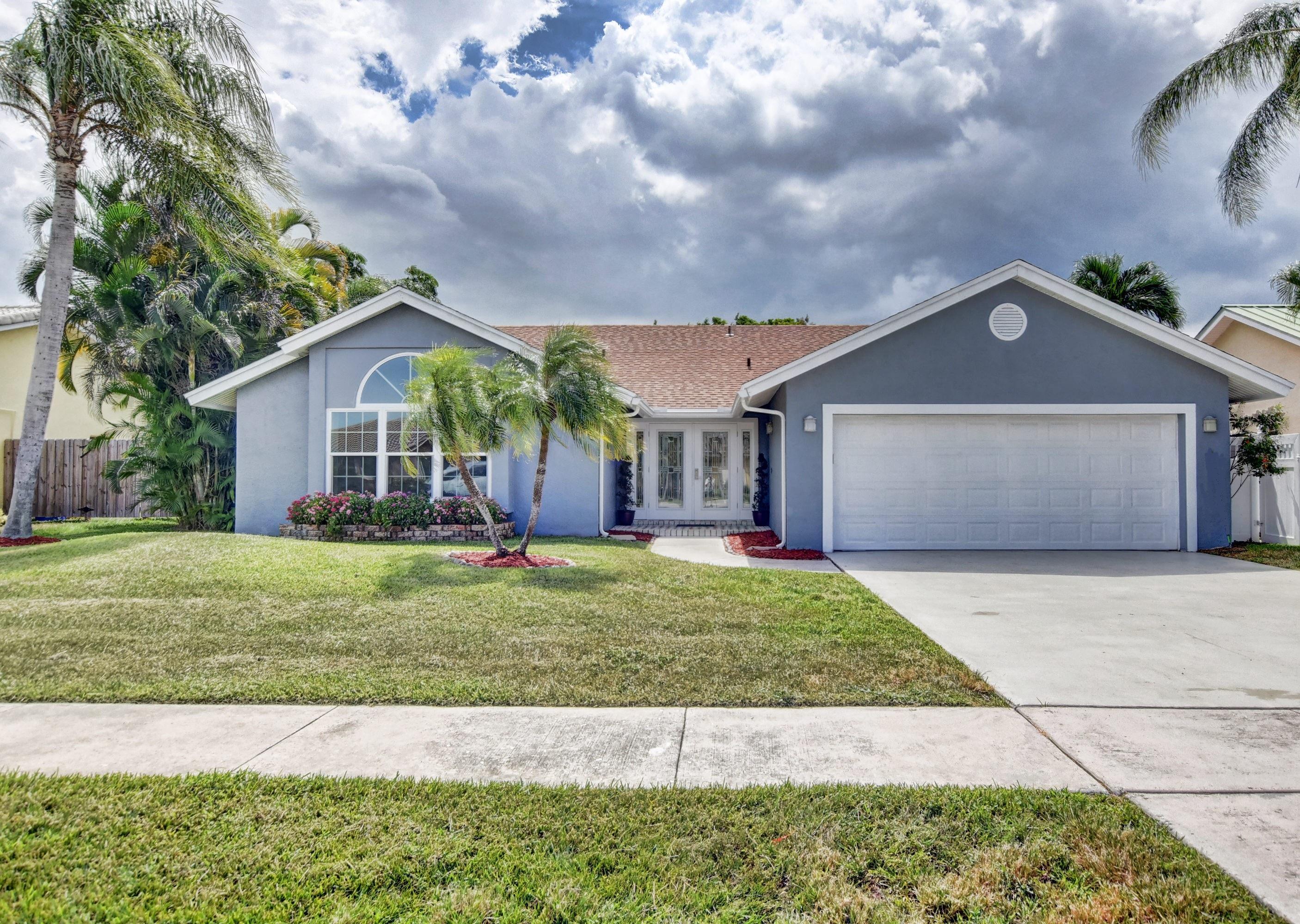 7445 Texas Trail Boca Raton, FL 33487 - Photo 1 of 28 a front view of a house with a garden