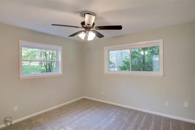 an empty room with a window and a fan