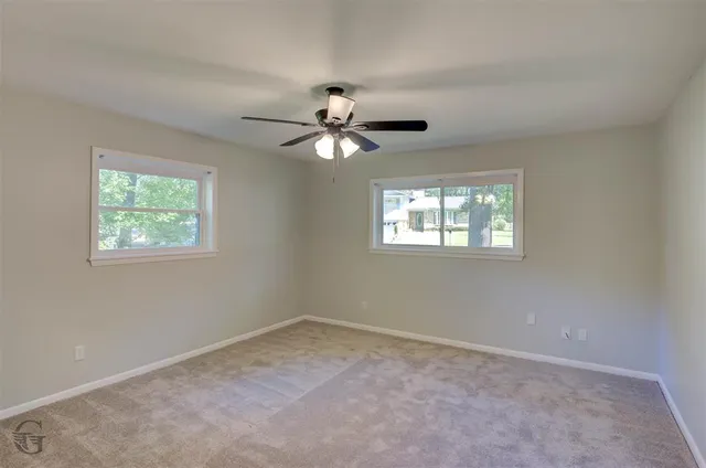 a view of a room with a ceiling fan and a window