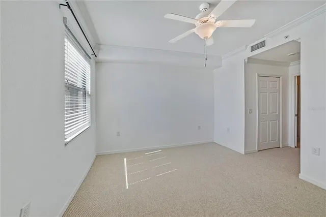 an empty room with a window and a fan