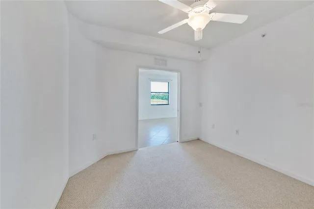 an empty room with a window and a fan