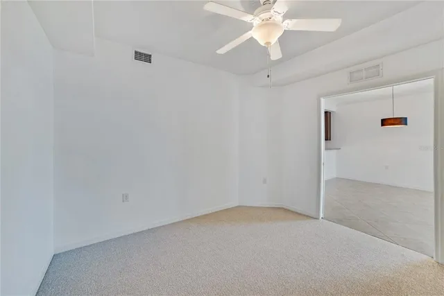 an empty room with a chandelier fan