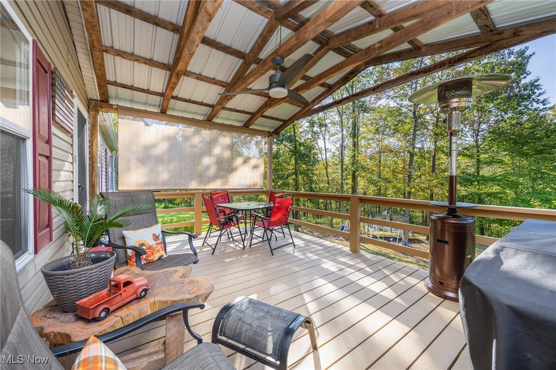 1788 Rosenbush Road Newport, OH 45768 - Photo 5 of 34 Front deck featuring ceiling fan, outdoor dining space, and view of scattered trees
