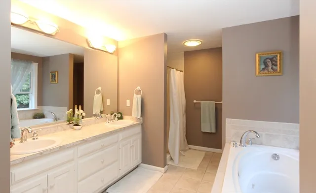 a bathroom with a tub sink and mirror