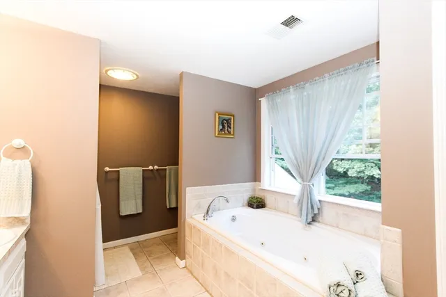 a bathroom with a tub a sink and a window