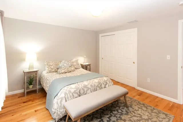 a bedroom with a bed and a wooden floor