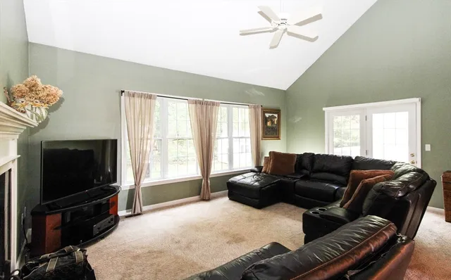 a living room with furniture a flat screen tv and a window