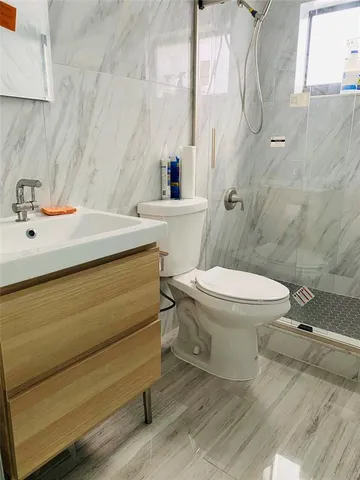 a bathroom with a sink mirror vanity and toilet