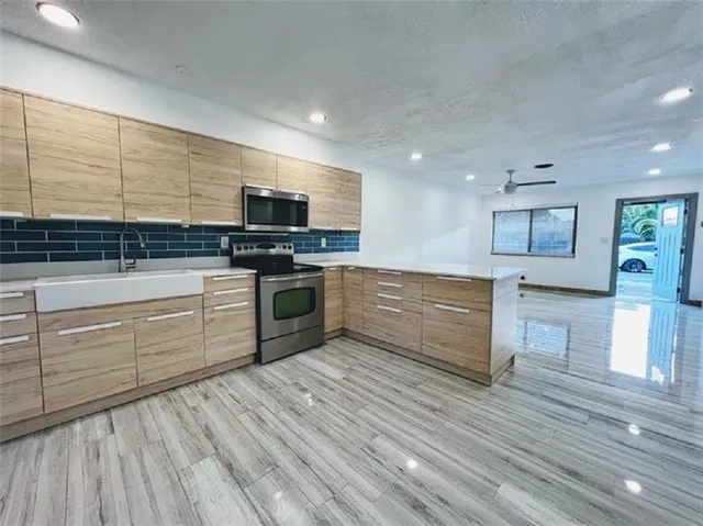 a kitchen with stainless steel appliances granite countertop a stove top oven and sink