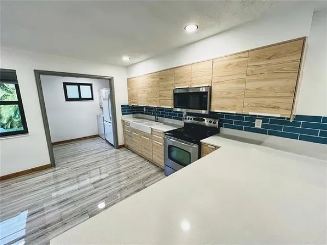a kitchen with stainless steel appliances a stove top oven a sink and a refrigerator