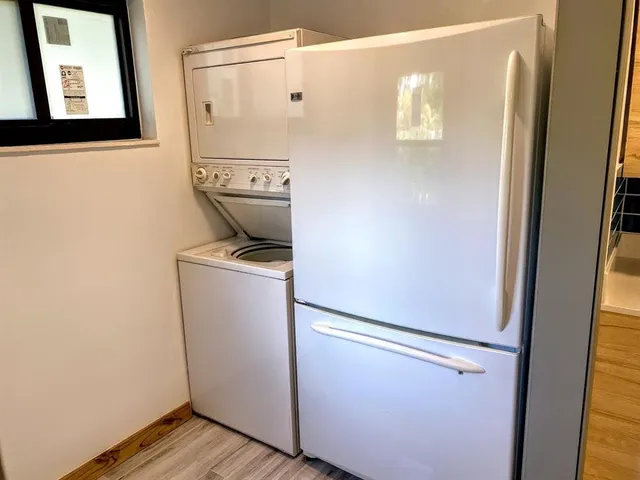 a utility room with wooden floor washer and dryer