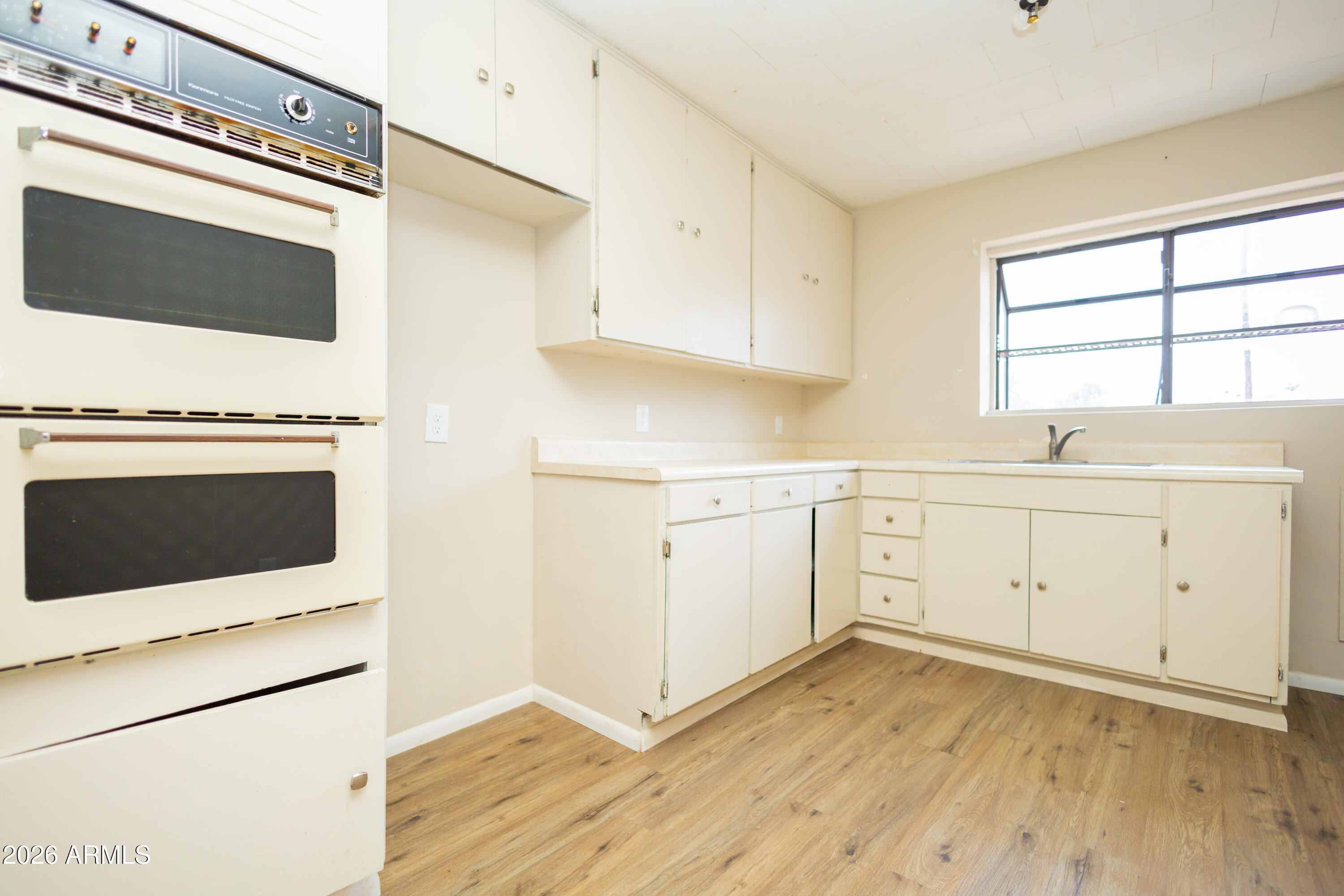 1626 11th Street Douglas, AZ 85607 - Photo 16 of 30 a kitchen with a stove oven and white cabinets