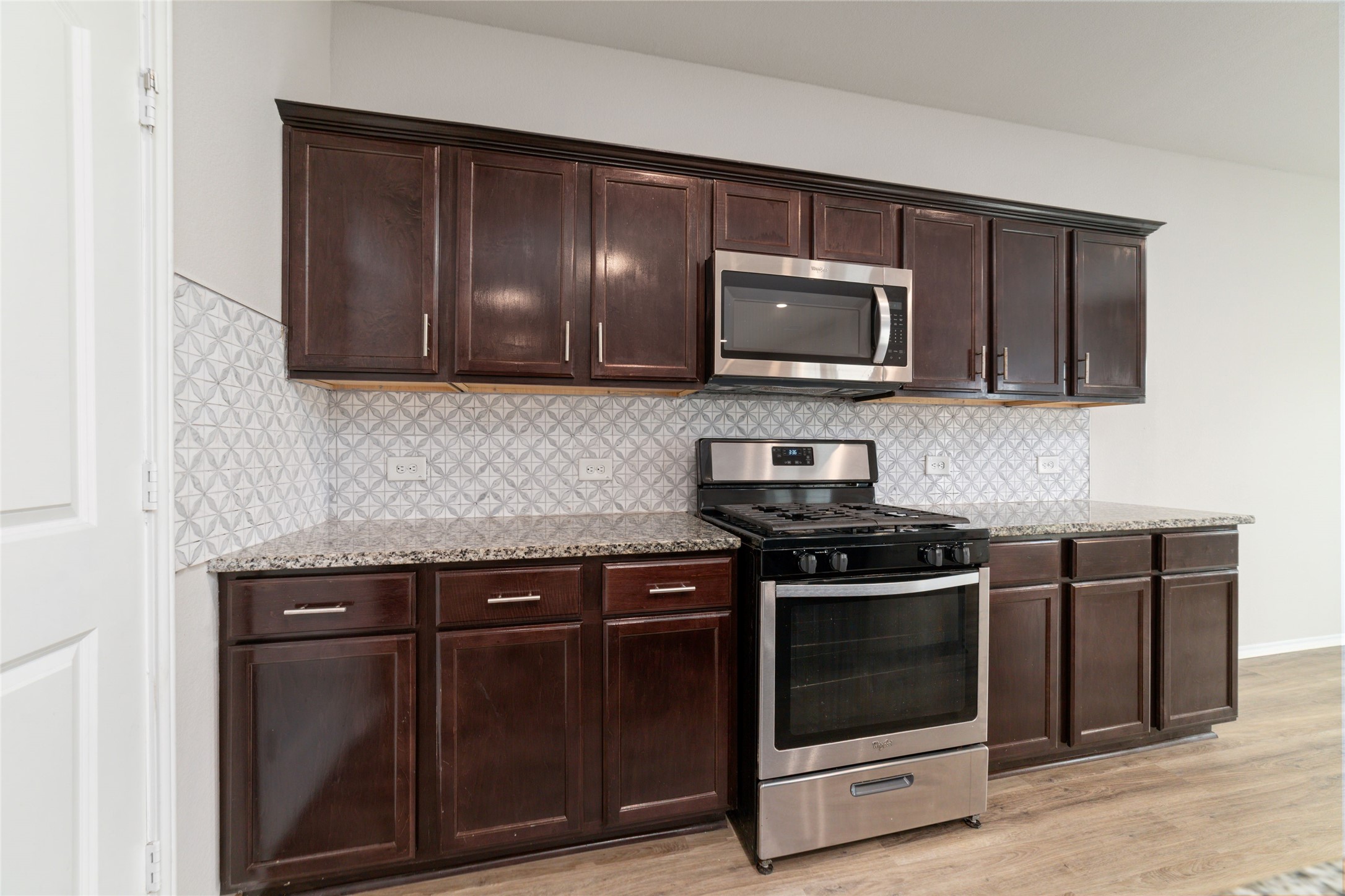 23702 Harrow Field Ln Spring Spring, TX 77373 - Photo 11 of 32 a kitchen with granite countertop wood cabinets and stainless steel appliances