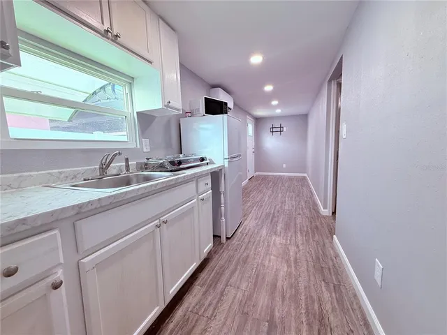 a bathroom with a sink a mirror and next to a window