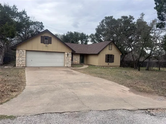 a view of a house with backyard and trees
