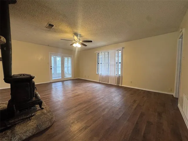 a view of a livingroom with wooden floor and a ceiling fan