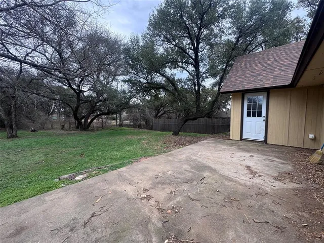 a view of a house with backyard and trees