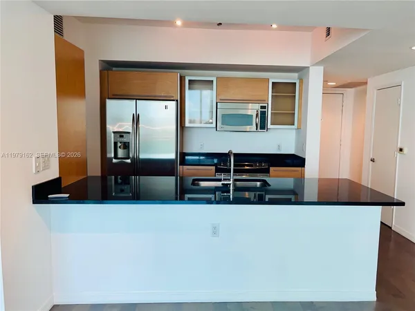 a living room with stainless steel appliances kitchen island a large counter top and a stove