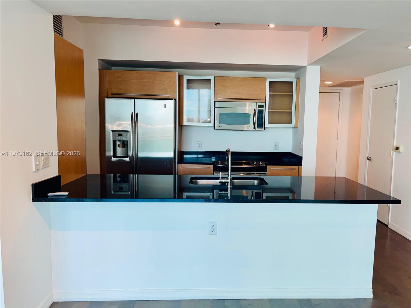 951 Brickell Avenue, Unit 3211 Miami, FL 33131 - Photo 1 of 35 a living room with stainless steel appliances kitchen island a large counter top and a stove