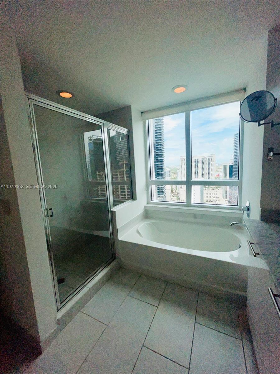 951 Brickell Avenue, Unit 3211 Miami, FL 33131 - Photo 13 of 35 a bathroom with a bathtub and a shower