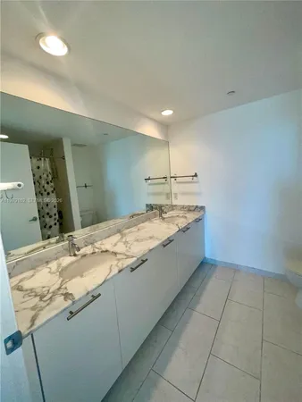 a bathroom with a granite countertop sink a toilet and a mirror