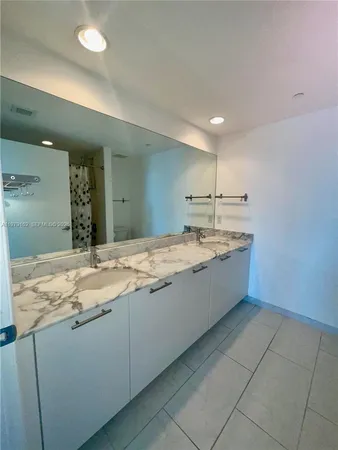 a bathroom with a granite countertop sink a mirror and vanity