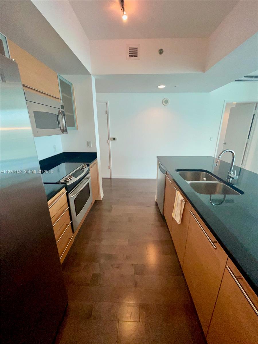 951 Brickell Avenue, Unit 3211 Miami, FL 33131 - Photo 24 of 35 a kitchen that has a sink and a stove
