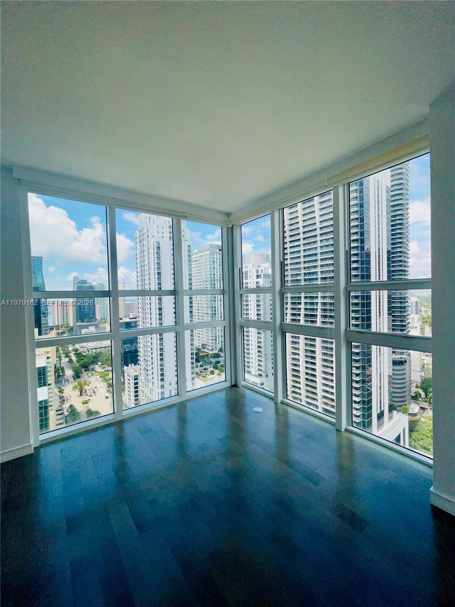 951 Brickell Avenue, Unit 3211 Miami, FL 33131 - Photo 28 of 35 a view of an empty room with wooden floor and a window