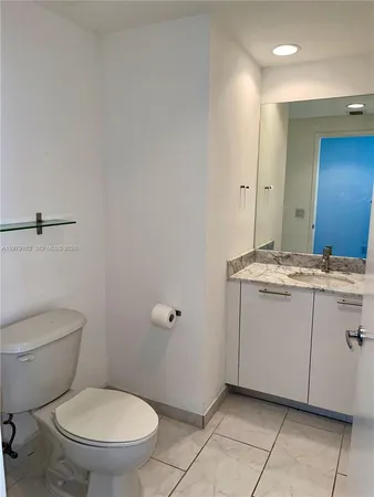 a bathroom with a granite countertop toilet and a sink