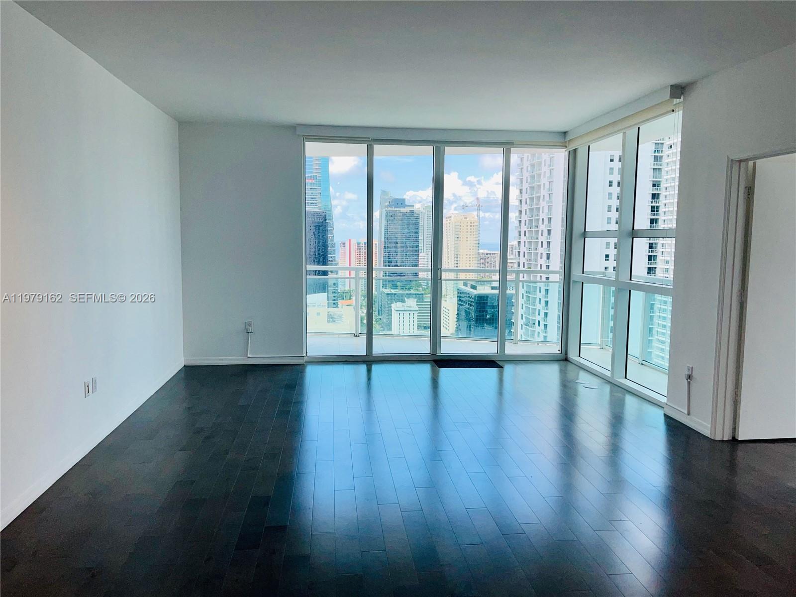 951 Brickell Avenue, Unit 3211 Miami, FL 33131 - Photo 5 of 35 a view of empty room with wooden floor and fan