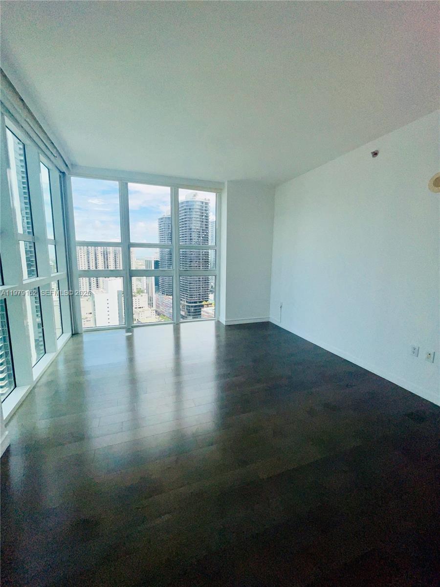 951 Brickell Avenue, Unit 3211 Miami, FL 33131 - Photo 8 of 35 wooden floor in an empty room with a window