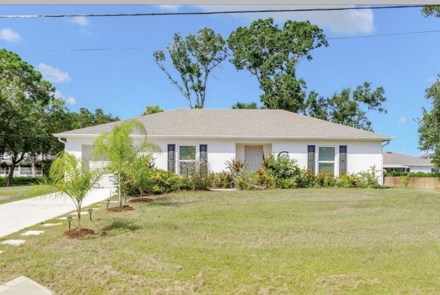 1281 Barber Street Sebastian, FL 32958 - Photo 1 of 26 a front view of a house with garden