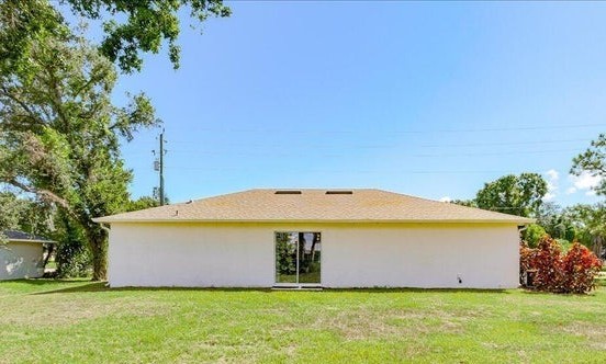 1281 Barber Street Sebastian, FL 32958 - Photo 19 of 26 a view of a big house with a small yard and large trees