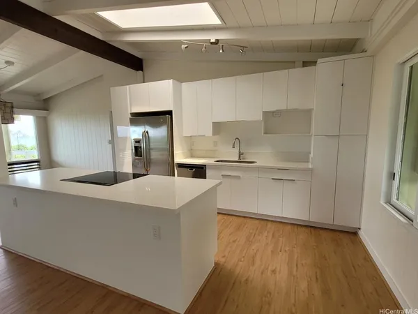 a kitchen with a sink a stove cabinets and wooden floor