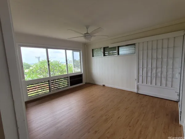 an empty room with wooden floor and windows