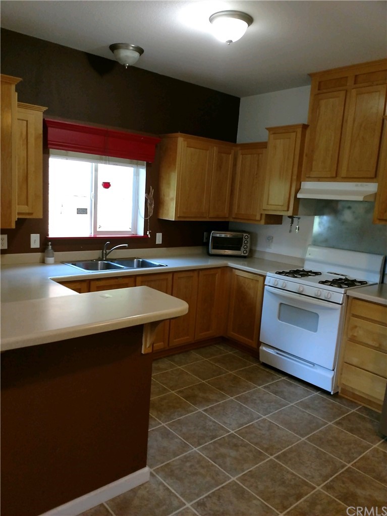 4236 Kakini Road Oroville, CA 95965 - Photo 5 of 36 a kitchen with stainless steel appliances a sink stove and cabinets