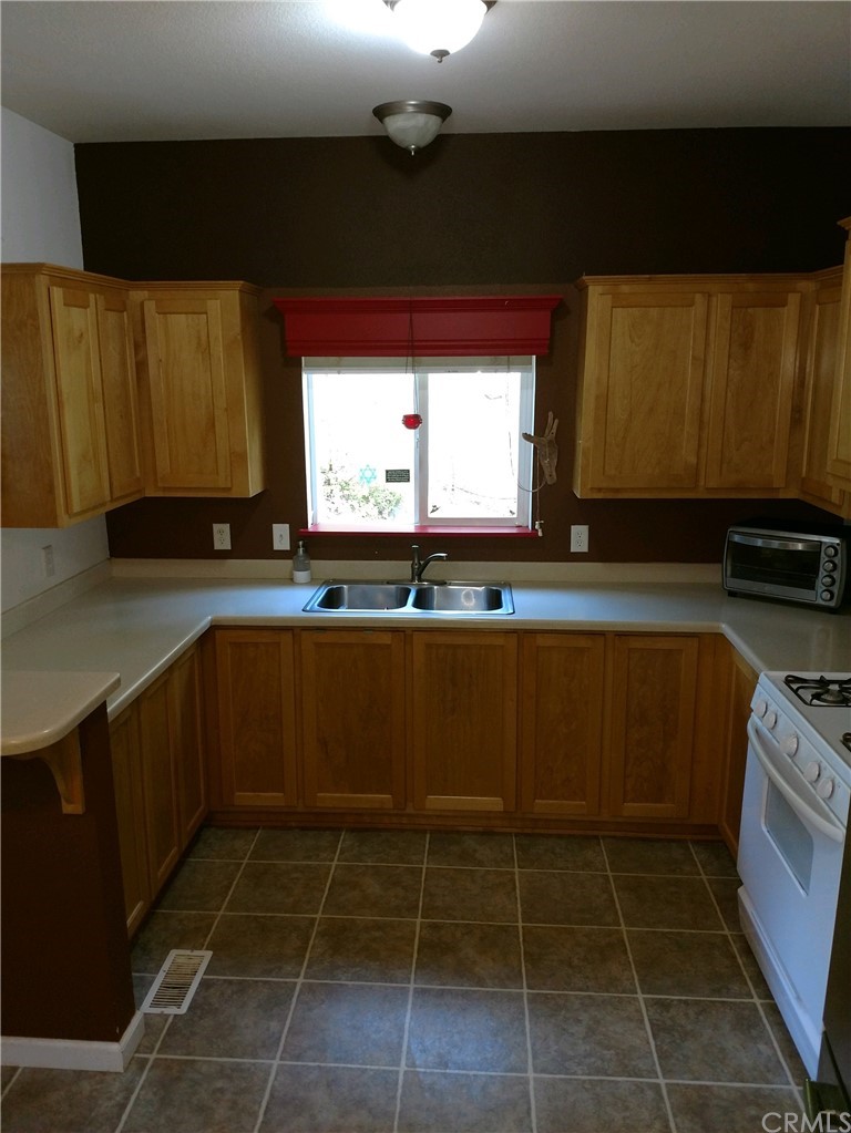 4236 Kakini Road Oroville, CA 95965 - Photo 7 of 36 a kitchen with a sink a stove top oven cabinetry and a window