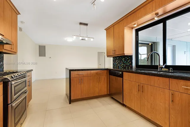 a kitchen with granite countertop a sink and a stove
