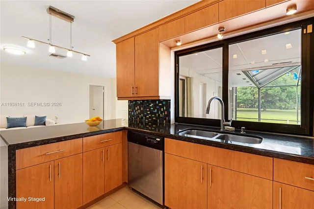 a living room with furniture kitchen view and a chandelier