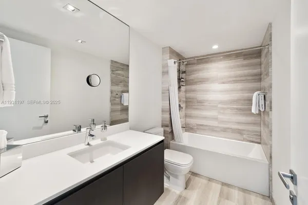 a bathroom with a sink toilet tub and shower