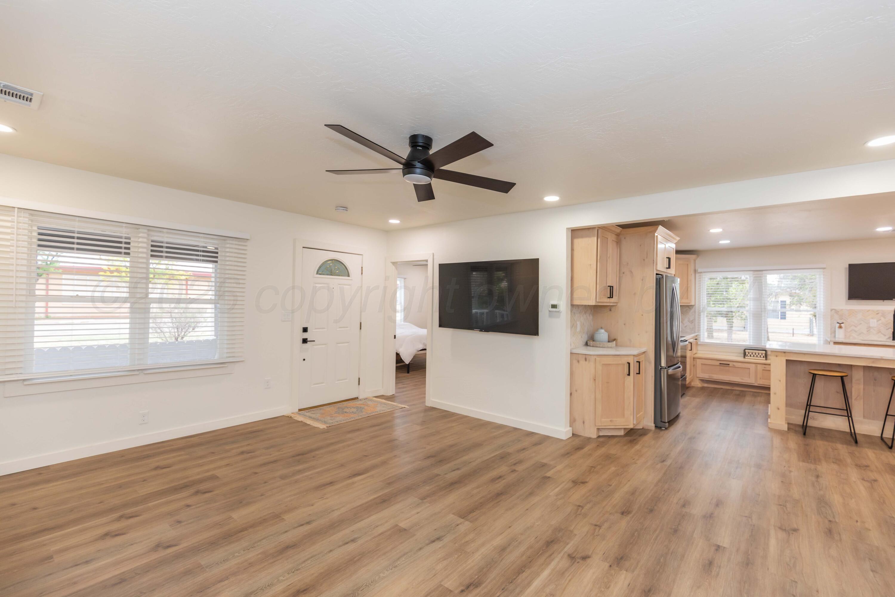 504 High Street Claude, TX 79019 - Photo 26 of 39 a view of a livingroom with a kitchen a ceiling fan and wooden floor