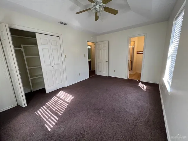 an empty room with windows and closet