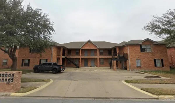 a view of a house with a cars park side of a road