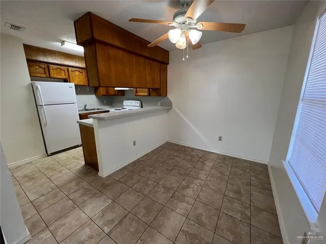 a view of kitchen with stainless steel appliances granite countertop a sink and a refrigerator