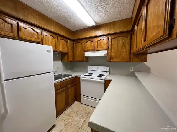 a kitchen with stainless steel appliances granite countertop a refrigerator a stove and a sink